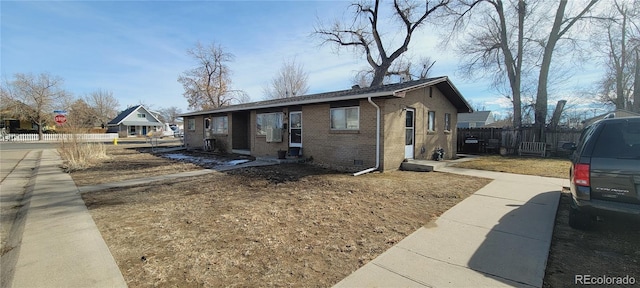 view of front of property featuring brick siding and fence