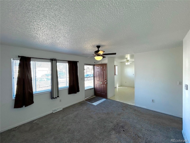 carpeted empty room featuring visible vents and a textured ceiling