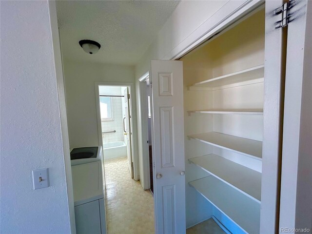 interior space featuring washer / clothes dryer, a textured ceiling, and tile patterned floors