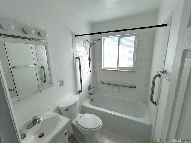 bathroom with a textured wall, bathing tub / shower combination, vanity, and toilet