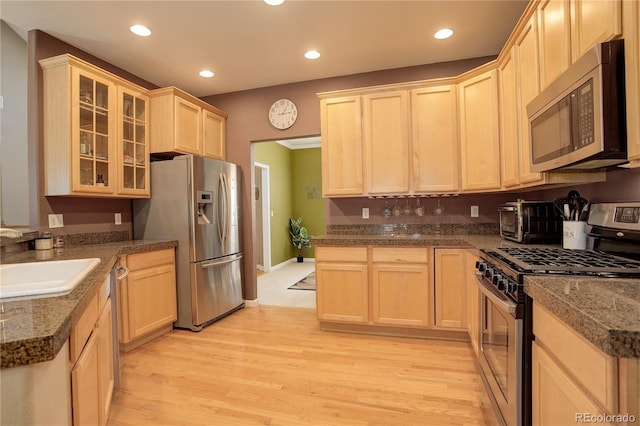 kitchen with light brown cabinets, sink, light hardwood / wood-style floors, and stainless steel appliances