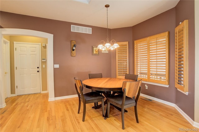 dining space featuring light hardwood / wood-style flooring and a notable chandelier