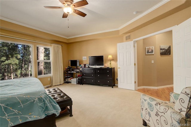 carpeted bedroom with ceiling fan and ornamental molding