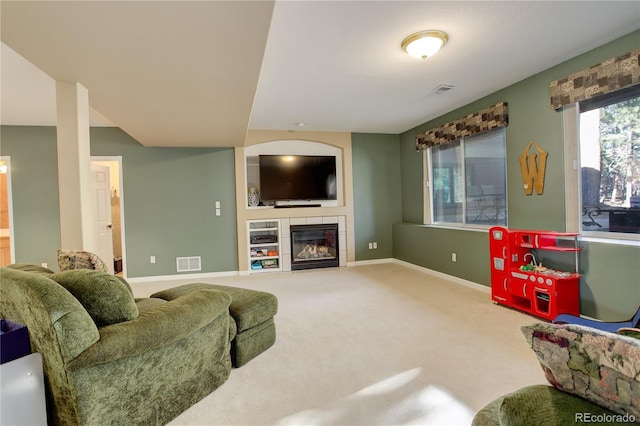 living room featuring a tile fireplace and carpet