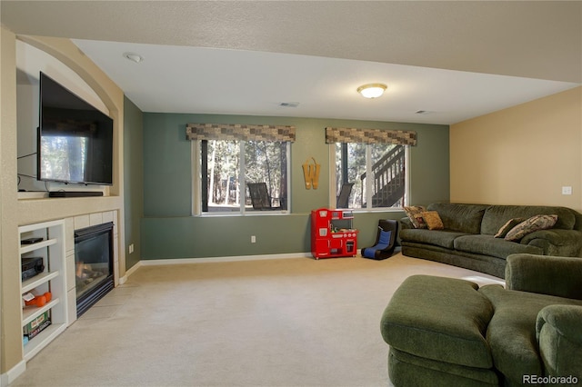 carpeted living room with a tile fireplace