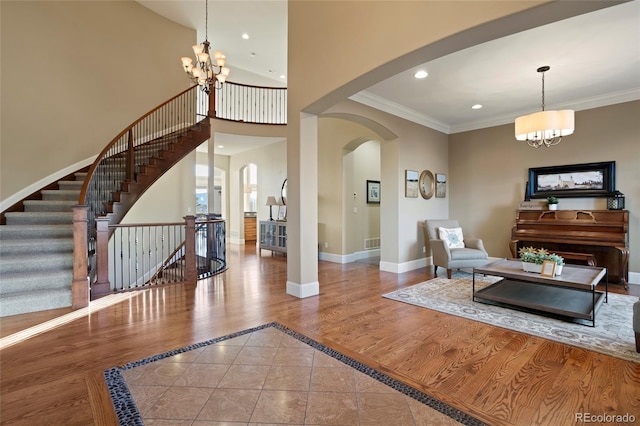 living room featuring tile patterned floors, ornamental molding, and a chandelier