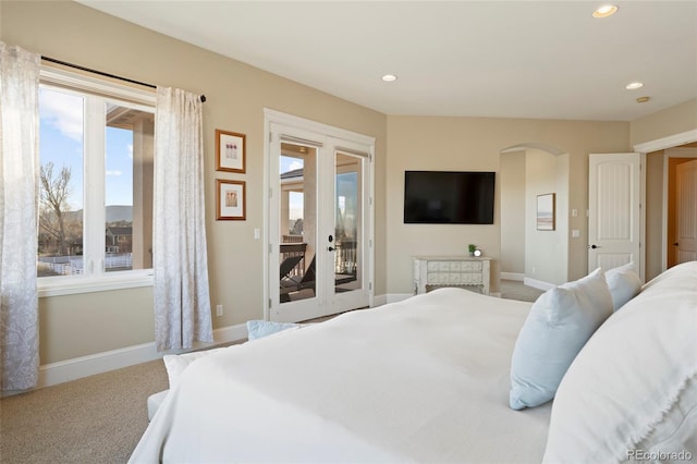 bedroom with access to outside, light carpet, and french doors