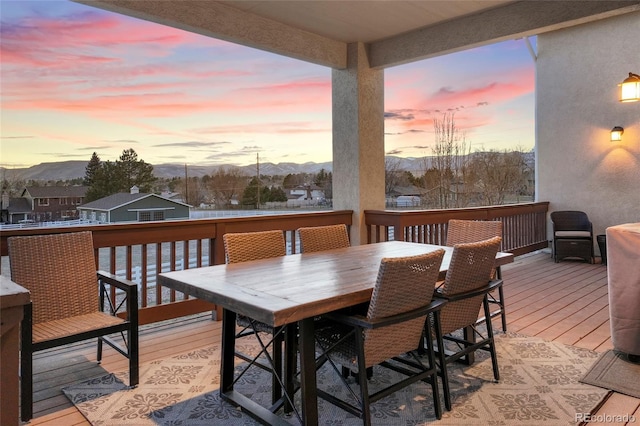 deck at dusk featuring a mountain view