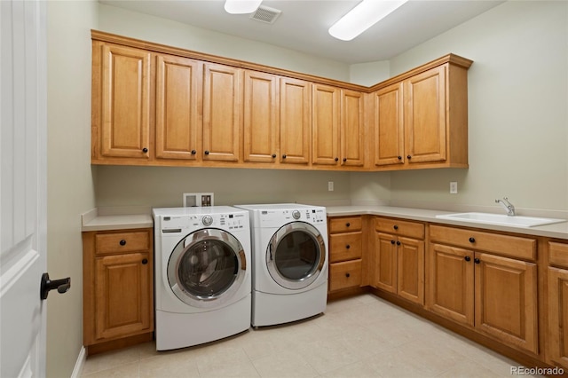 washroom featuring washing machine and clothes dryer, sink, and cabinets