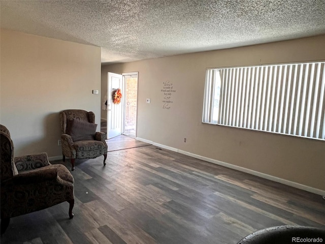 living area with a textured ceiling and hardwood / wood-style flooring