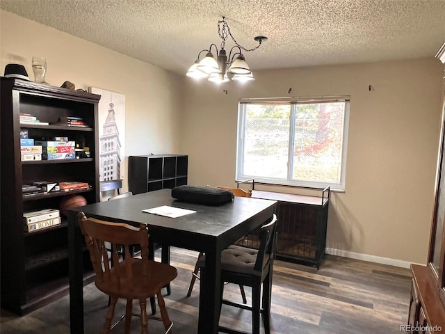 dining space featuring hardwood / wood-style floors, a textured ceiling, and an inviting chandelier