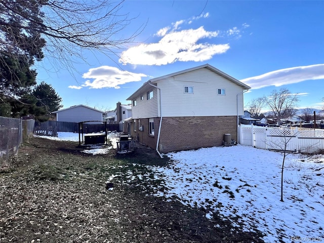 snow covered rear of property with a trampoline