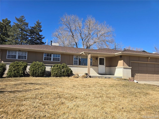 ranch-style home featuring brick siding, an attached garage, driveway, and a front yard