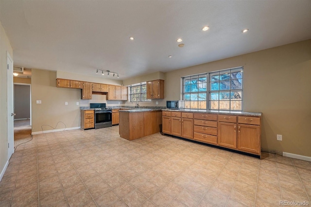 kitchen with brown cabinetry, range, and baseboards