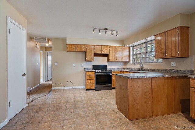 kitchen with visible vents, a sink, stainless steel range oven, a peninsula, and brown cabinetry