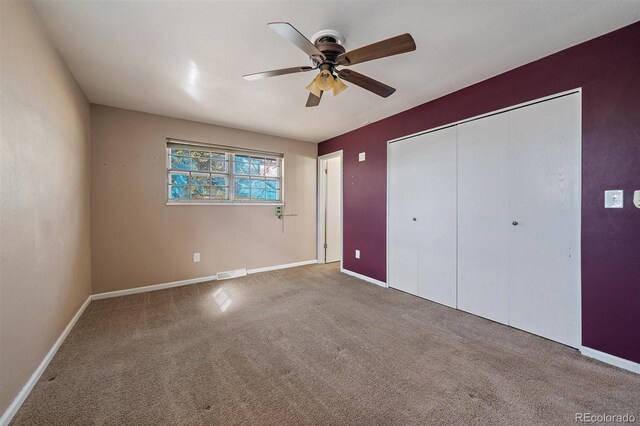 unfurnished bedroom featuring visible vents, baseboards, carpet floors, a closet, and a ceiling fan