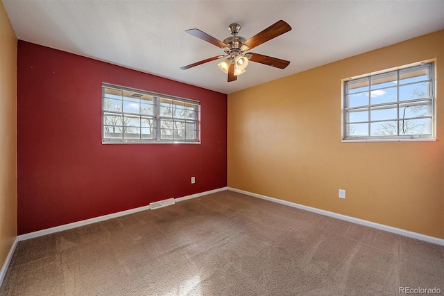 spare room with visible vents, baseboards, ceiling fan, and carpet flooring