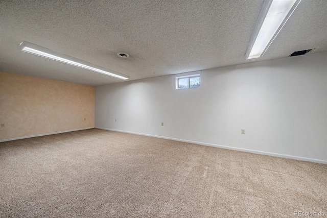 unfurnished room featuring visible vents, carpet floors, a textured ceiling, and baseboards