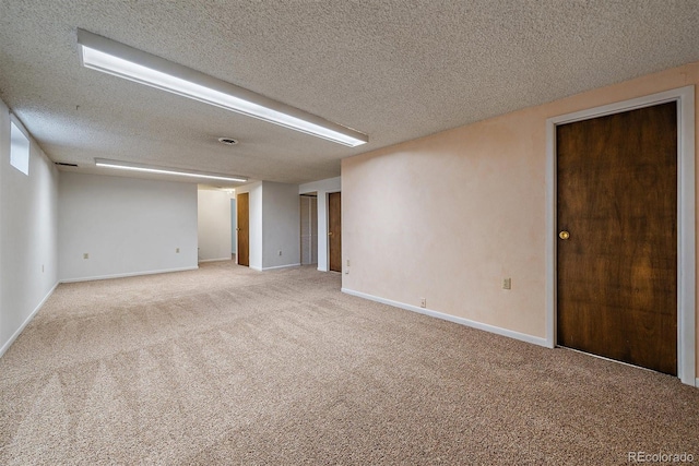 spare room featuring baseboards, a textured ceiling, and carpet