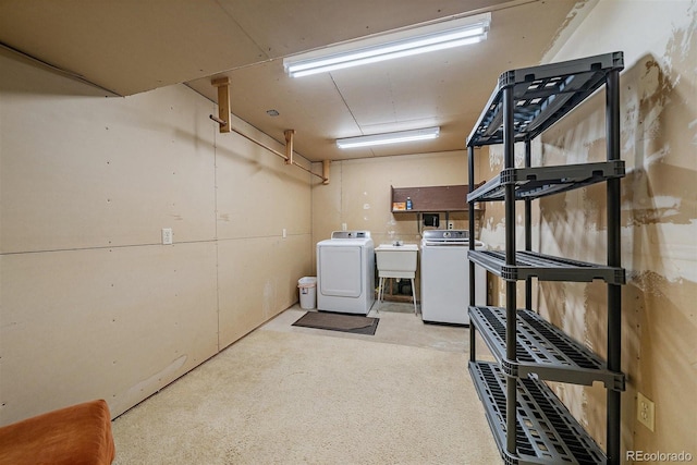 basement featuring washing machine and dryer and a sink