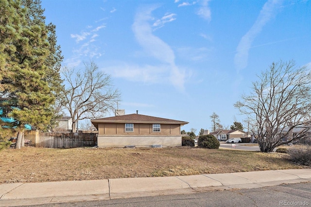 view of side of property with fence, brick siding, and a chimney