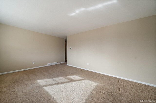 unfurnished room featuring baseboards, visible vents, and carpet floors