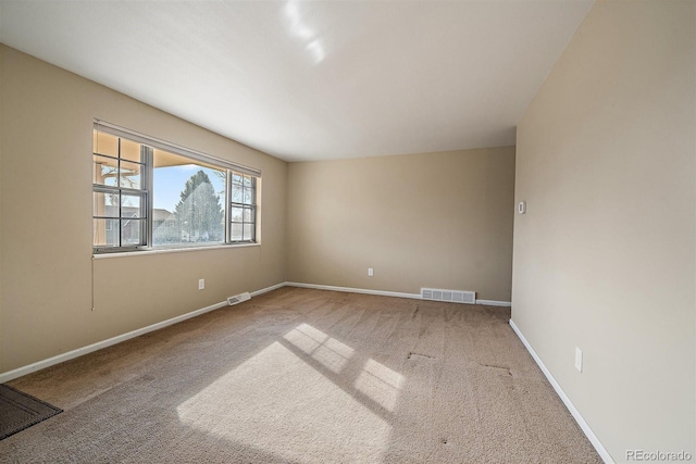 carpeted empty room with visible vents and baseboards