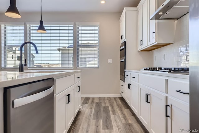 kitchen with pendant lighting, dishwasher, white cabinetry, backsplash, and black gas cooktop