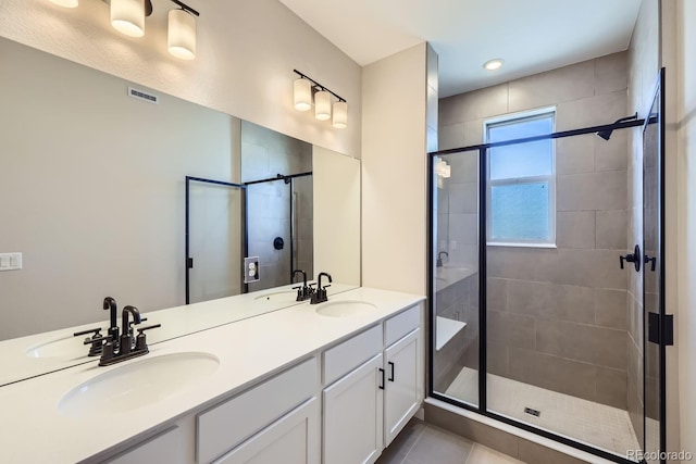 bathroom featuring a shower with door, vanity, and tile patterned floors