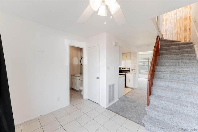 stairway with tile patterned floors, visible vents, and ceiling fan