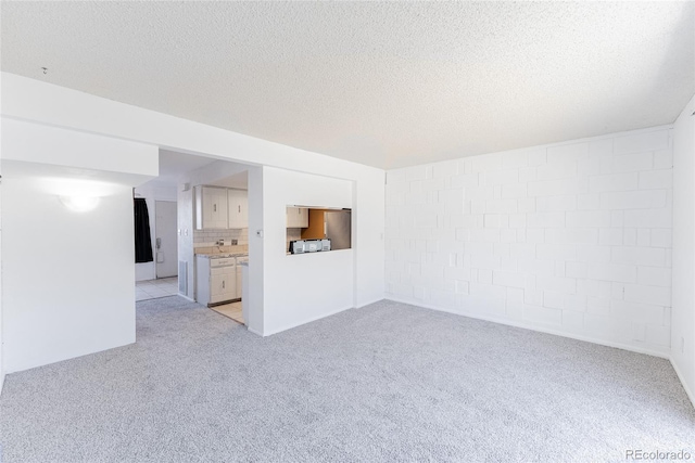 unfurnished living room featuring a textured ceiling and light carpet