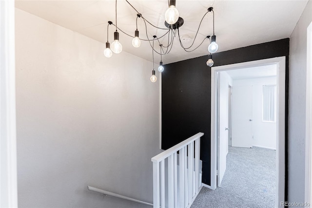 stairway with carpet and a chandelier