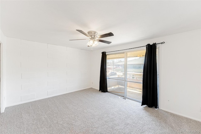 carpeted spare room featuring visible vents and a ceiling fan