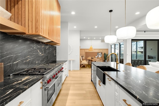 1001 S Adams St, Denver, CO 80209 - kitchen featuring double oven range, a sink, light wood-style floors, tasteful backsplash, and white cabinetry
