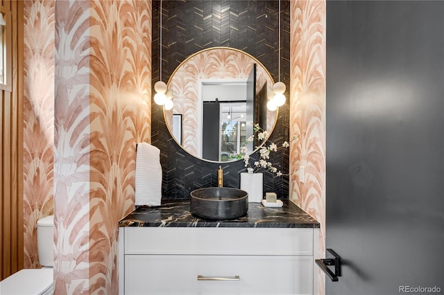 1001 S Adams St, Denver, CO 80209 - bathroom featuring wallpapered walls, toilet, vanity, and tasteful backsplash