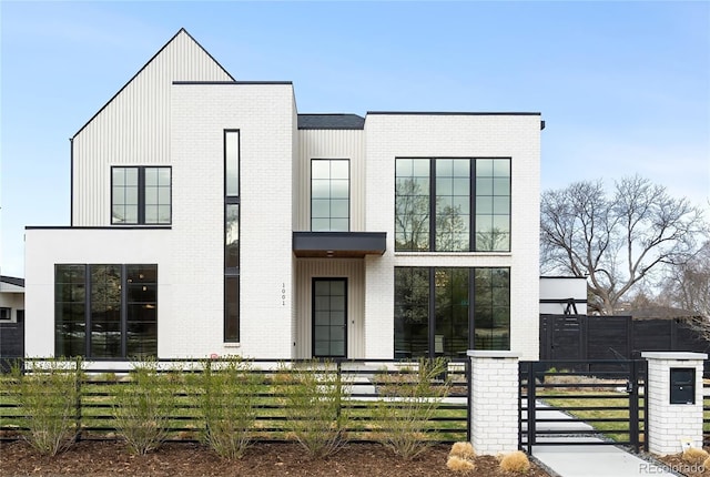 1001 S Adams St, Denver, CO 80209 - modern home featuring a fenced front yard, brick siding, and a gate