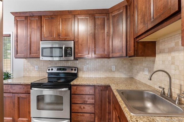 995 Ironton St, Aurora, CO 80010 - kitchen with stainless steel appliances, backsplash, and light stone counters