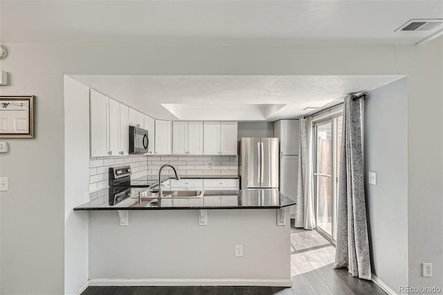 kitchen featuring a sink, dark countertops, visible vents, and stainless steel appliances