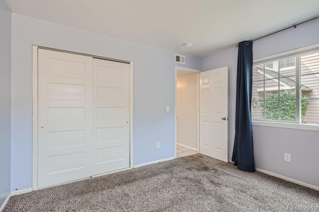 unfurnished bedroom featuring visible vents, baseboards, a closet, and carpet flooring