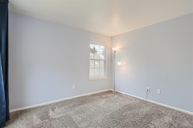 empty room featuring carpet flooring and baseboards