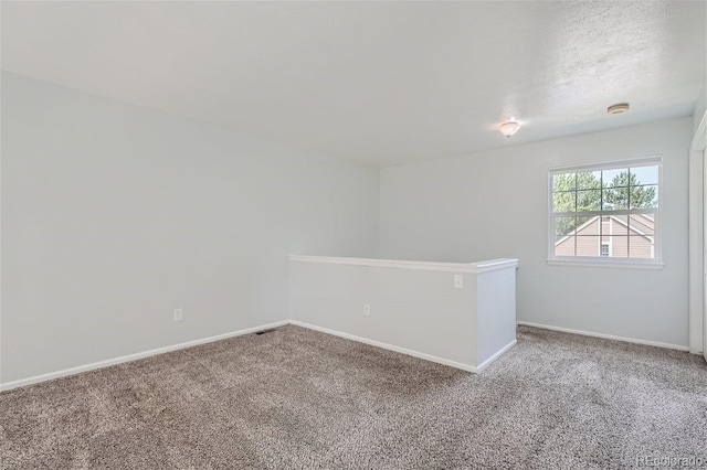 unfurnished room featuring carpet flooring, a textured ceiling, and baseboards