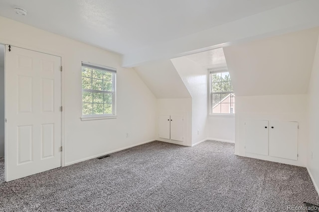 bonus room with visible vents, baseboards, lofted ceiling with beams, and carpet