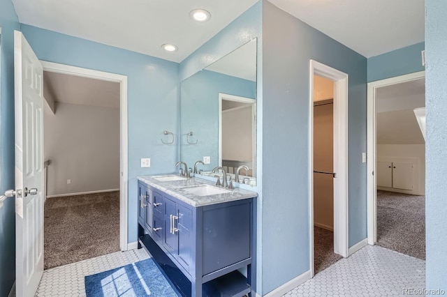 full bathroom with a sink, double vanity, a spacious closet, and tile patterned floors