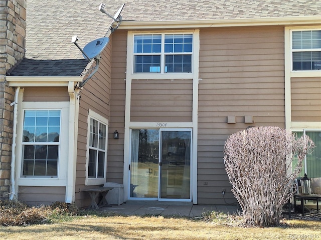 rear view of house with a shingled roof