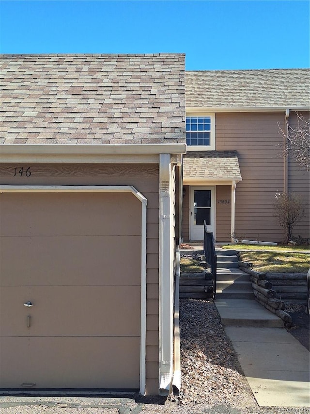 exterior space featuring a garage and a shingled roof