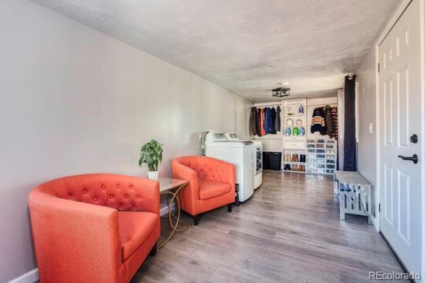 sitting room featuring wood-type flooring and washer and clothes dryer