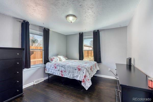 bedroom with dark wood-type flooring and a textured ceiling