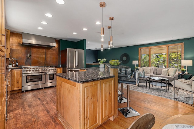 15 Pawnee Dr, Boulder, CO 80303 - kitchen with premium appliances, wall chimney range hood, dark wood-style flooring, a kitchen bar, and a kitchen island