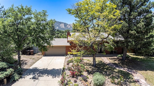 15 Pawnee Dr, Boulder, CO 80303 - obstructed view of property featuring a garage, driveway, a mountain view, and a chimney