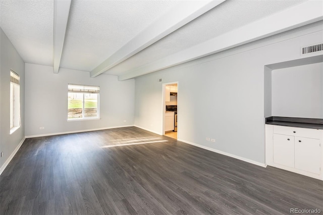 unfurnished living room featuring beamed ceiling, dark wood-type flooring, and a textured ceiling